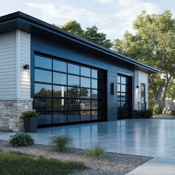 Twin full-view aluminum glass garage doors with black frames on a stone-and-siding modern home