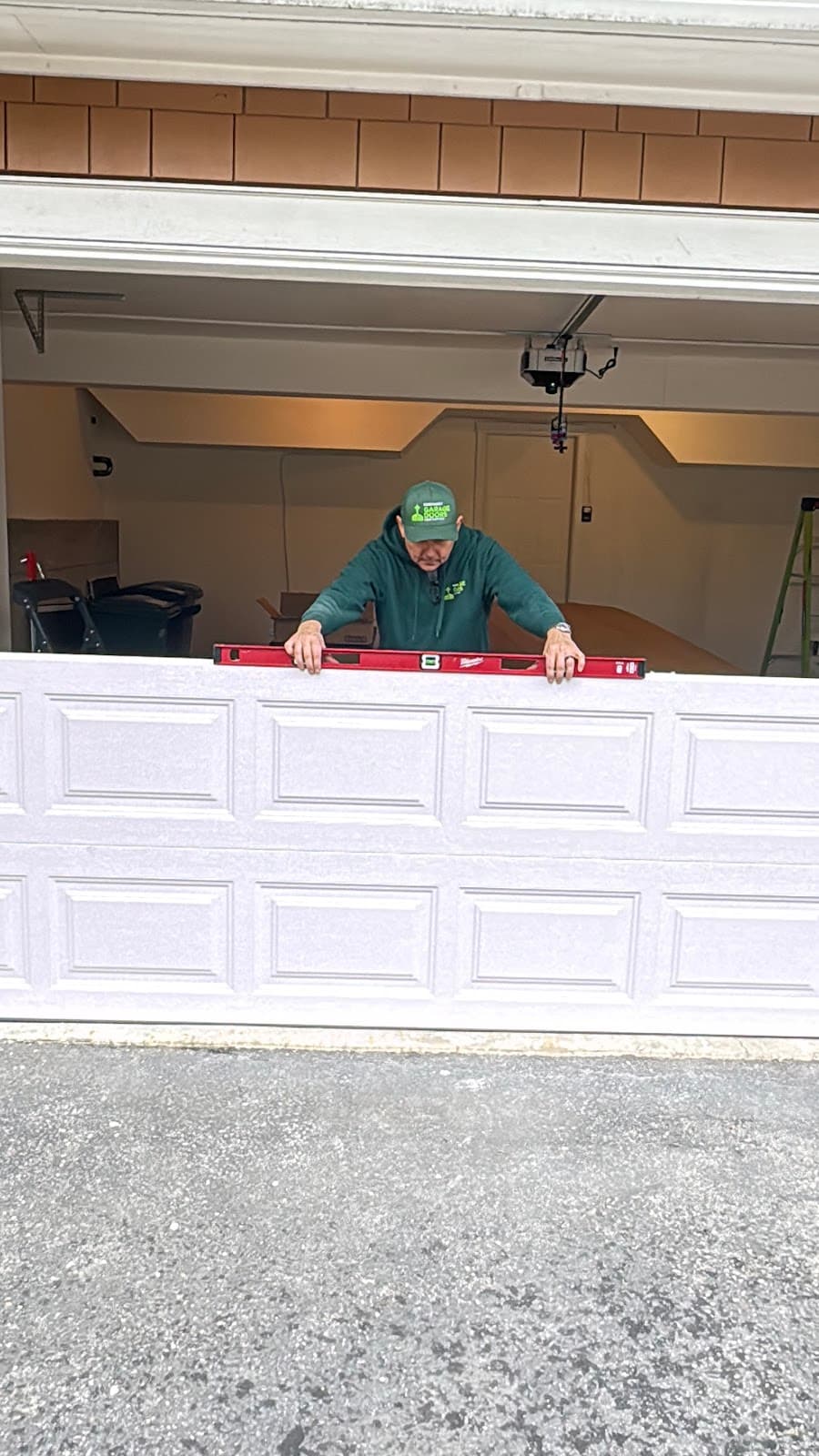 Technician leveling garage door during service