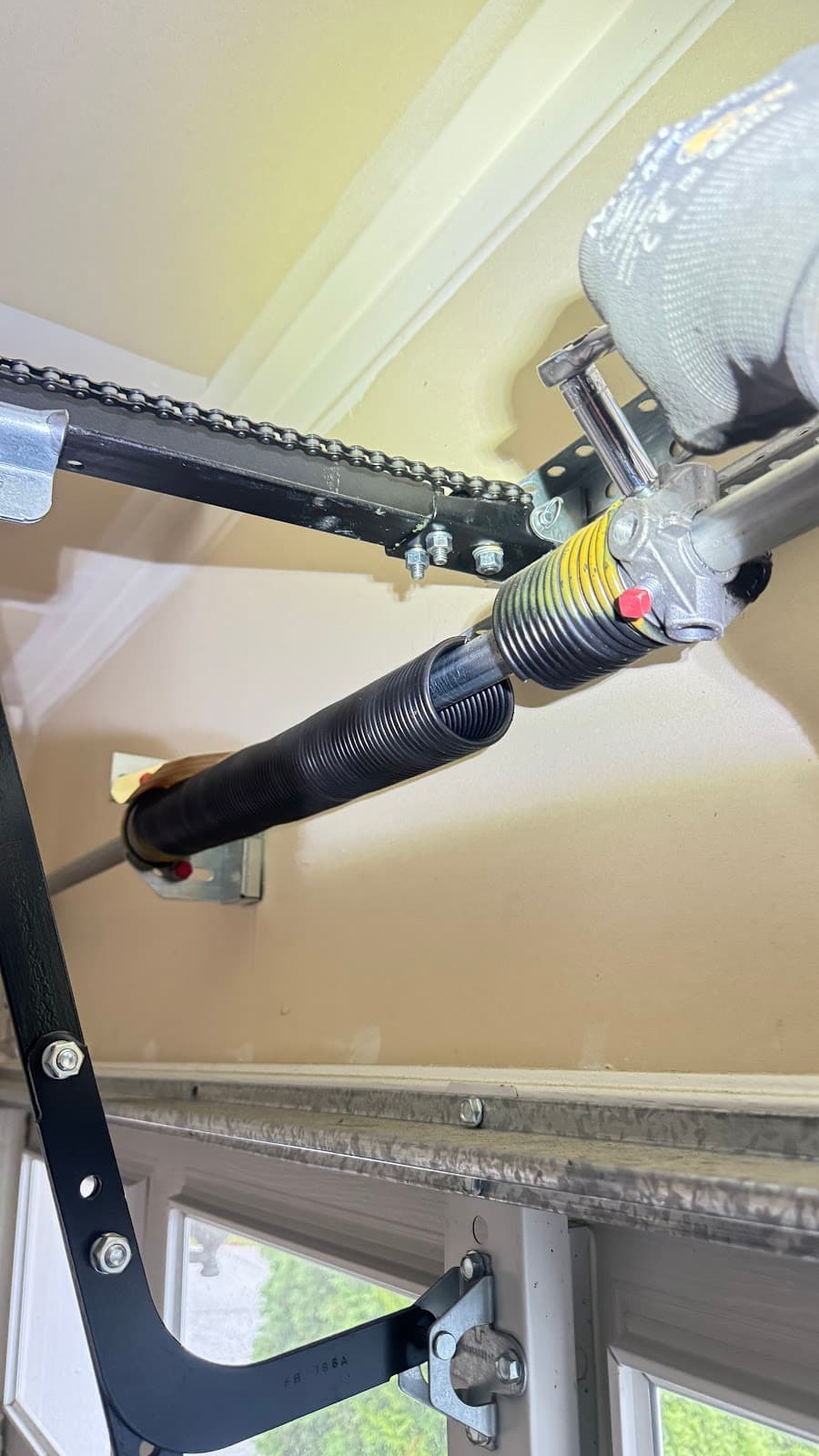 Technician repairing garage door torsion spring